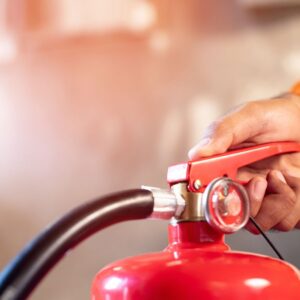 a view of someone pushing on the handle of a red fire extinguisher